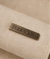 Bermuda Linho Resort na cor areia, placa metálica com a marca Serravero aplicada ao tecido